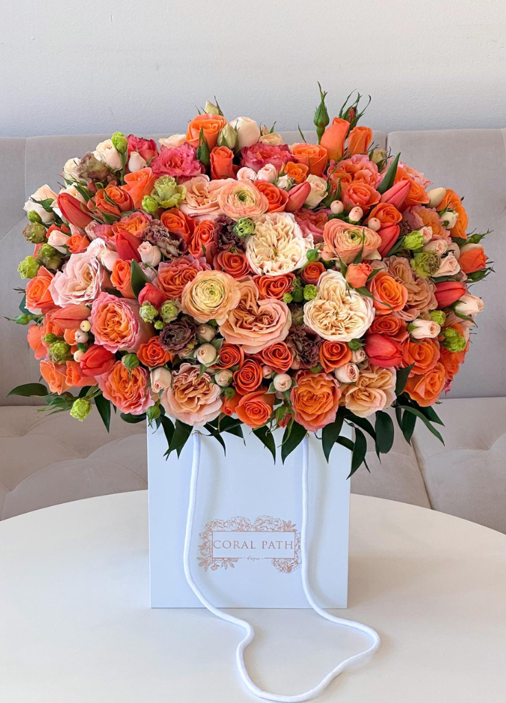 Fall inspired flowers featuring bright orange roses, ivory garden roses and other fillers.