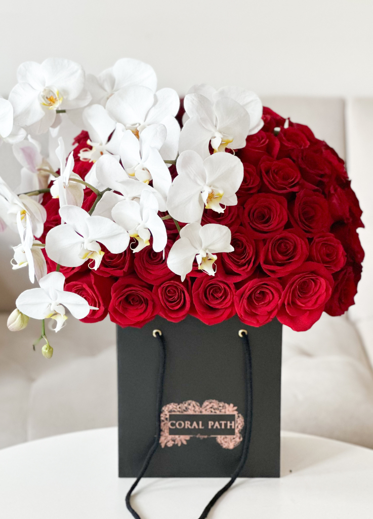 Phalaenopsis orchids and red roses in a bag box.